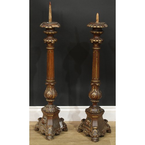 1403 - A pair of North European parcel-gilt oak altar pricket candlesticks, fluted pillars, acanthus socles... 