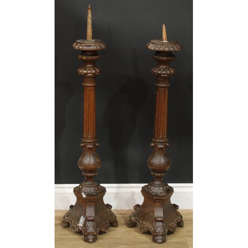 1403 - A pair of North European parcel-gilt oak altar pricket candlesticks, fluted pillars, acanthus socles... 