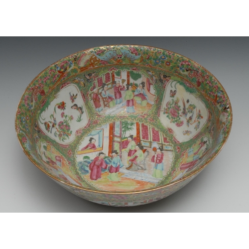 765 - A Cantonese punch bowl, typically painted in famille rose enamels with figures in gardens and interi... 