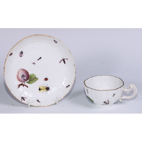 524 - A Meissen cup and saucer, painted in polychrome with insects, fruit and pea pods, on a moulded groun... 