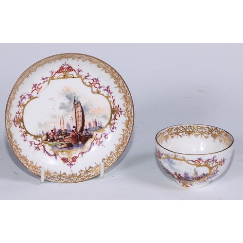 525 - A Meissen tea bowl and saucer, painted in polychrome with harbour views, gilt borders, the saucer 12... 