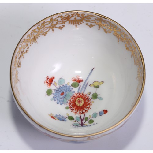 525 - A Meissen tea bowl and saucer, painted in polychrome with harbour views, gilt borders, the saucer 12... 