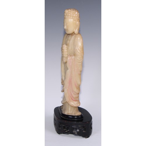 799 - A Chinese soapstone figure, carved as Buddha holding a pagoda, carved hardwood stand, 41cm high, ear... 