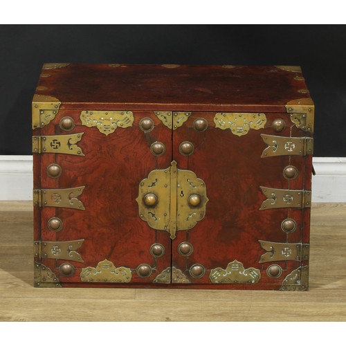 1021 - A Chinese brass mounted enclosed table cabinet, flush rectangular top above a pair of yumu veneer pa... 