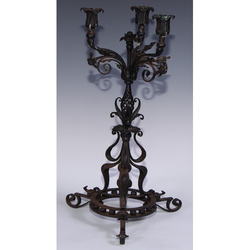 1148 - An Arts and Crafts wrought iron three light candelabra, worked in the Art Nouveau taste with flowers... 