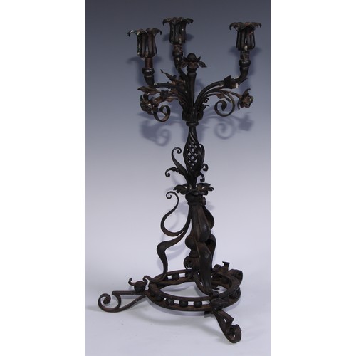 1148 - An Arts and Crafts wrought iron three light candelabra, worked in the Art Nouveau taste with flowers... 