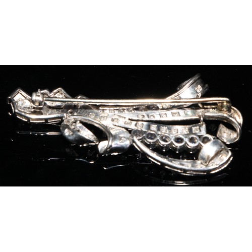 374 - An early 20th century unmarked platinum brooch, as a ribbon tied leafy floral scroll, set with an ar... 