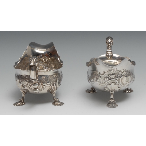 185 - A pair of George II Rococo silver sauce boats, chased with flowers, leaves and scrolls, acanthus-cap... 