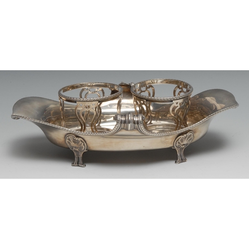 110 - A George III Rococo silver boat shaped oil and vinegar cruet stand, gadrooned scroll border, scroll ... 