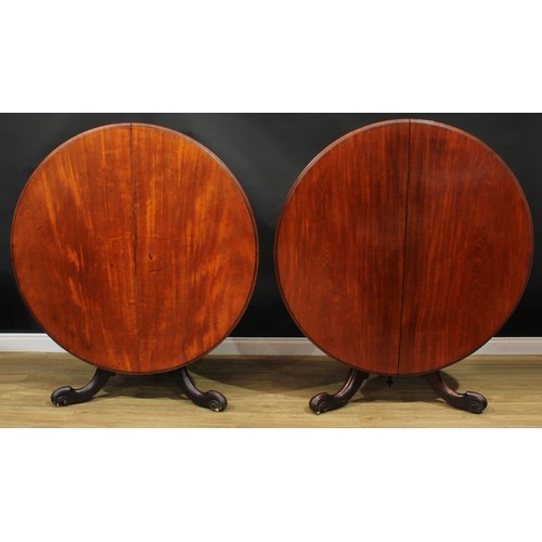 1408 - A pair of Victorian mahogany centre tables, each with a circular tilting top with moulded edge and w... 