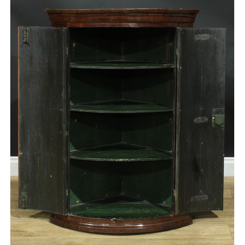 1237 - A George III mahogany wall hanging bowfront corner cupboard, moulded cornice above a pair of doors e... 