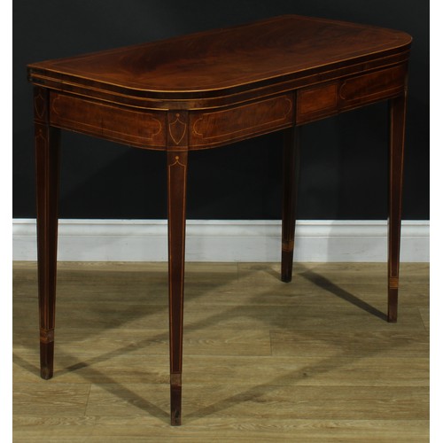 1394 - A pair of George III mahogany D-shaped card tables, each with a hinged crossbanded top enclosing a b... 