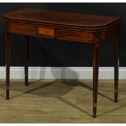 1394 - A pair of George III mahogany D-shaped card tables, each with a hinged crossbanded top enclosing a b... 