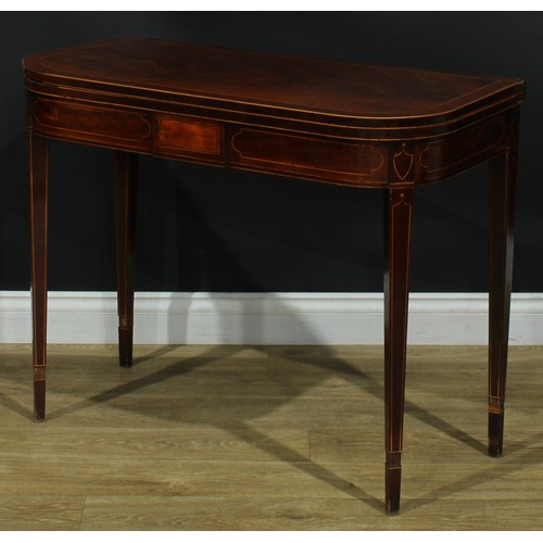 1394 - A pair of George III mahogany D-shaped card tables, each with a hinged crossbanded top enclosing a b... 