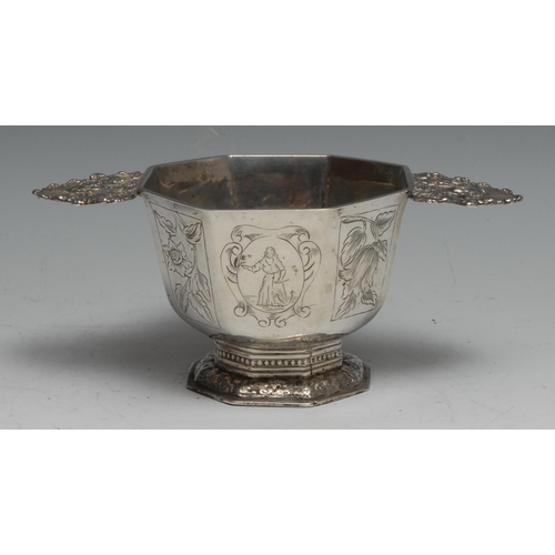 247 - An 18th century Dutch silver octagonal pedestal porringer or brandy bowl, engraved with panels of fi... 