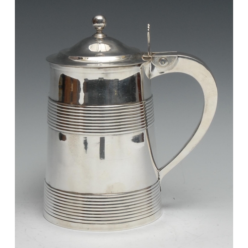 133 - A George III silver tankard, hinged domed cover with ball finial and pierced thumb-piece, above two ... 