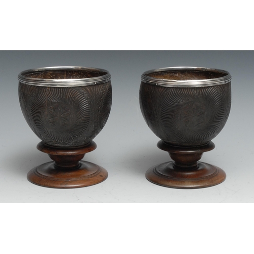 171 - A pair of 18th centurty silver mounted coconut cups, each carved with fluted roundels and Rococo car... 