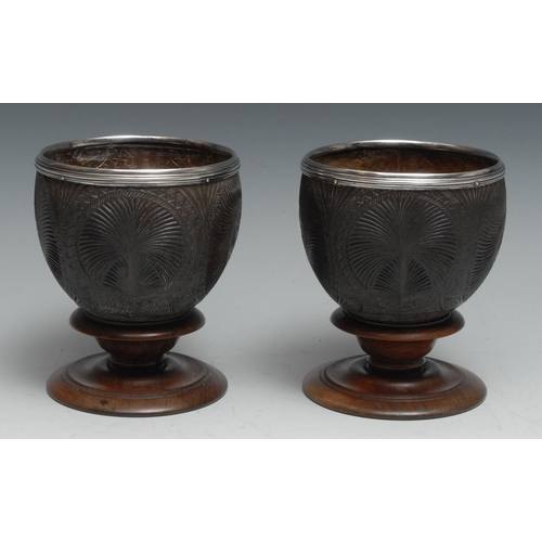 171 - A pair of 18th centurty silver mounted coconut cups, each carved with fluted roundels and Rococo car... 