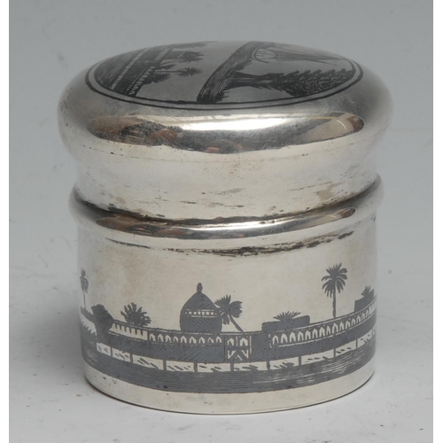 289 - An Iraqi silver and niello cylindrical box and cover, decorated with an Arab Desert scene, 5cm high