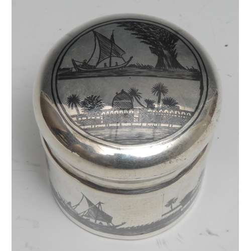 289 - An Iraqi silver and niello cylindrical box and cover, decorated with an Arab Desert scene, 5cm high