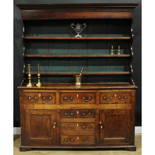 1241 - A George III oak and elm dresser, moulded cornice with dentil capital above three plate rack shelves... 