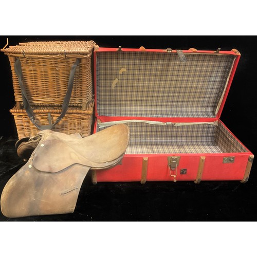 828 - A wood bound steamer trunk; a leather saddle; a wicker fishing basket; another (4)