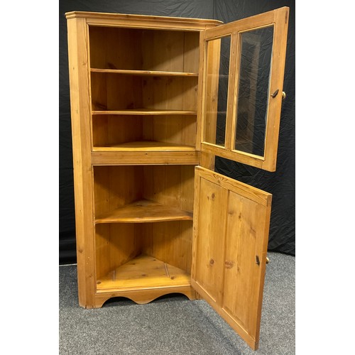 39 - A Victorian pine floor-standing corner cupboard, glazed door to top, and two-panel pine door to base... 