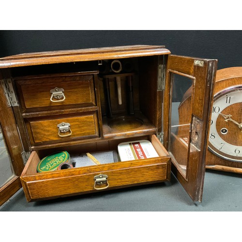 102 - A 20th century oak smokers cabinet, lift up lid, two glazed doors, fitted interior with three drawer... 