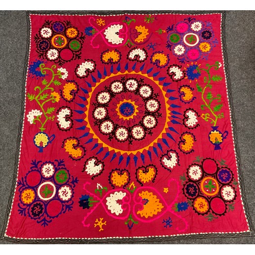 140 - An Uzbeck Suzanie, woven in shades of orange, purple, and white on a magenta ground, 185cm x 165cm.