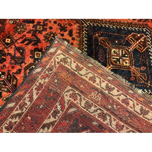 162 - A South-west Persian Shiraz carpet, hand-knotted in earthy shades of red, brown, cream, and deep blu... 