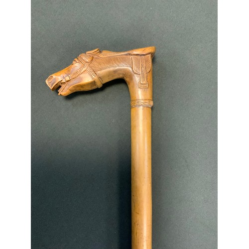 172 - A Victorian walking stick, the handle carved with horses head and saddle, 89cm long, c.1890