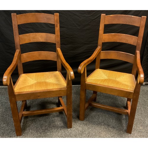 177 - A pair of oak Nigel/Rupert Griffiths style arched lath back carver chairs, rush seats, shaped arms, ... 