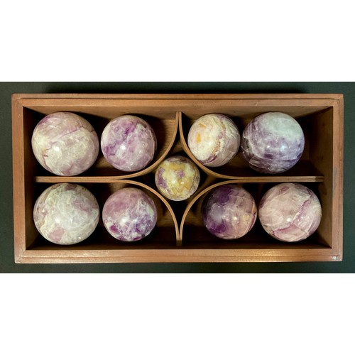 336 - A set of Nine Amethyst and hard stone balls, various sizes, in mahogany case