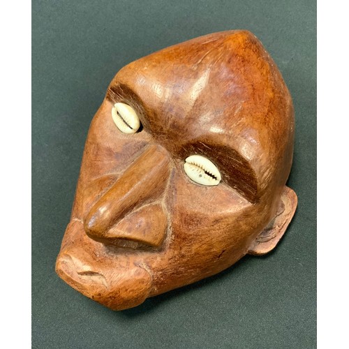 82 - An Oceania carved wooden maskhead, inset Cowrie shell eyes, 19.5cm high, 15.5cm wide