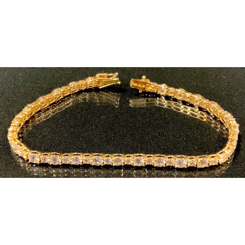 450 - A 14ct gold cubic zirconia tennis bracelet, 19cm long, stamped 585, 11.0g gross