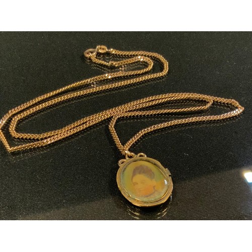 458 - A late Victorian gold coloured metal oval photograph locket, suspended from a 9ct gold chain, 12.5 g... 