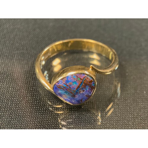 478 - A black opal ring, free form deep opal, flashing violet, pinky red, blue and green, 18ct gold shank,... 