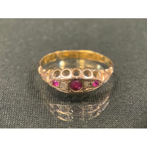 481 - A 19th century diamond and ruby ring, with three graduated pink red rubies divided by rose cut diamo... 