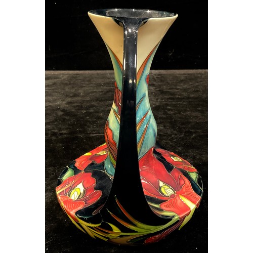 38 - A contemporary Moorcroft two handled vase, tube lined with irises in shades of red and orange on a d... 