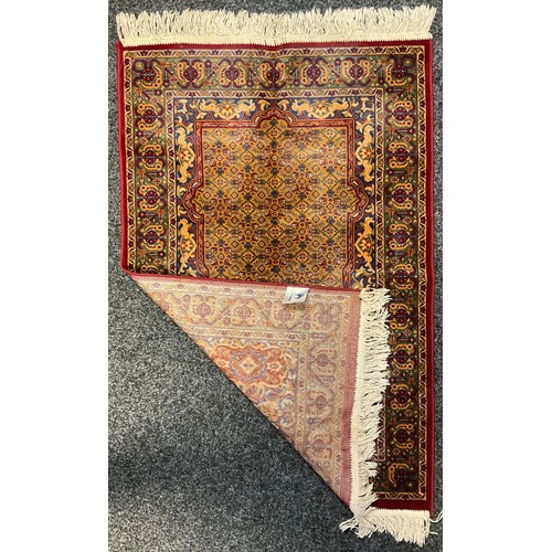 224 - An Islamic woollen prayer mat, Saudi Arabia, geometric design in shades of red, blue, green and ochr... 