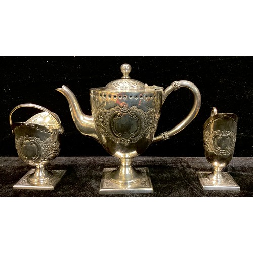 250 - A silver plated three piece tea service, domed pedestal teapot, embossed with foliate scrolls, squar... 