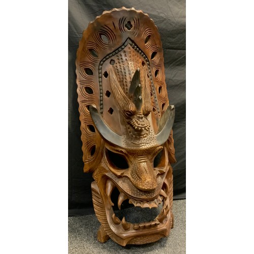 56 - A large carved tribal dragon demon mask, possibly Indonesian, with grotesque pronounced features, ap... 