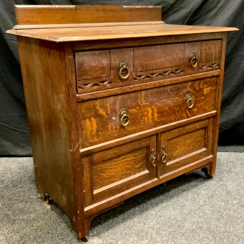 295 - A carved oak chest, three slightly graduated drawers, brass ring handles, bracket feet, castor termi... 