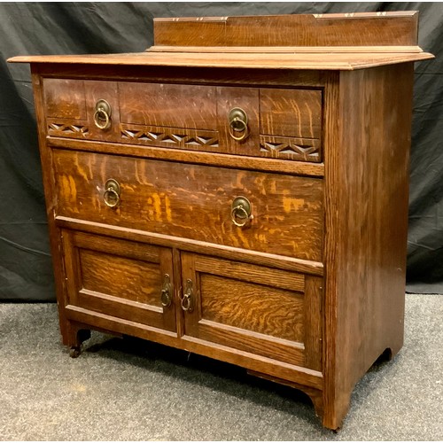 295 - A carved oak chest, three slightly graduated drawers, brass ring handles, bracket feet, castor termi... 