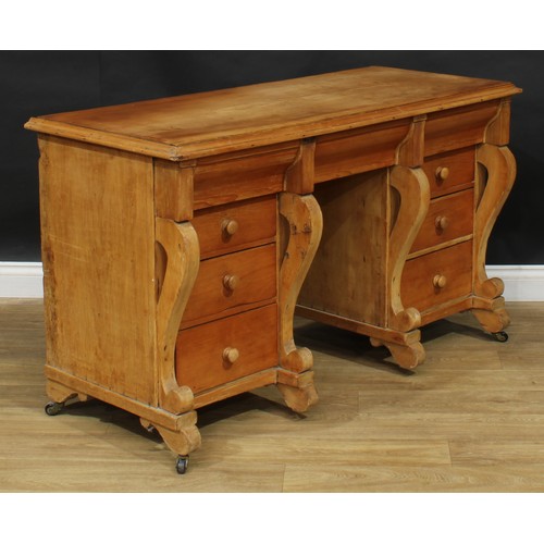 105 - A late 19th/early 20th century pine kneehole desk, rectangular top with moulded edge above an arrang... 