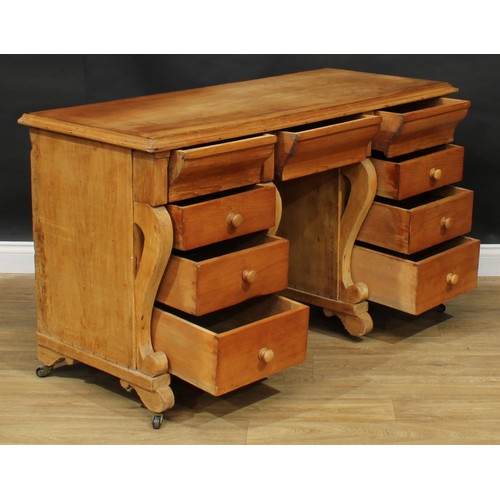 105 - A late 19th/early 20th century pine kneehole desk, rectangular top with moulded edge above an arrang... 