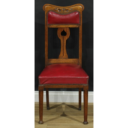 215 - A set of four Arts & Crafts period oak dining chairs, each with a shaped splat pierced in the Art No... 