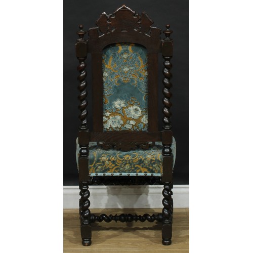 217 - A set of four Carolean Revival oak dining chairs, each creating rail carved and applied with the hea... 