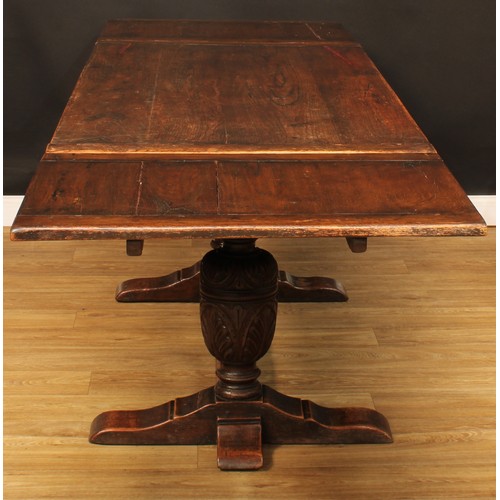 218 - An Elizabethan design oak draw-leaf dining table, rectangular top with two sliding leaves, above a f... 