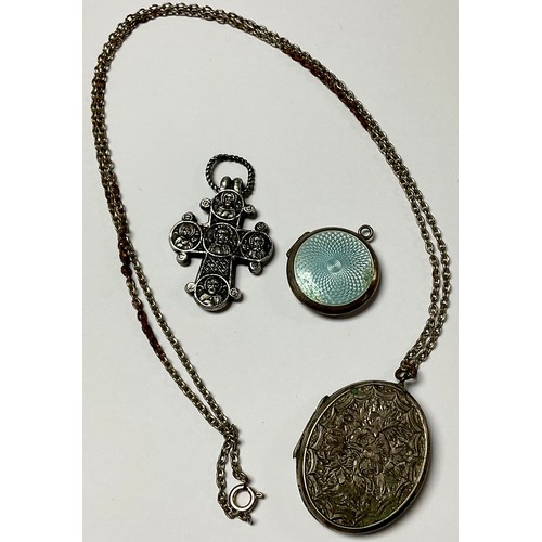 1156 - A Victorian oval silver locket; an enamel and silver locket; a cross (3)